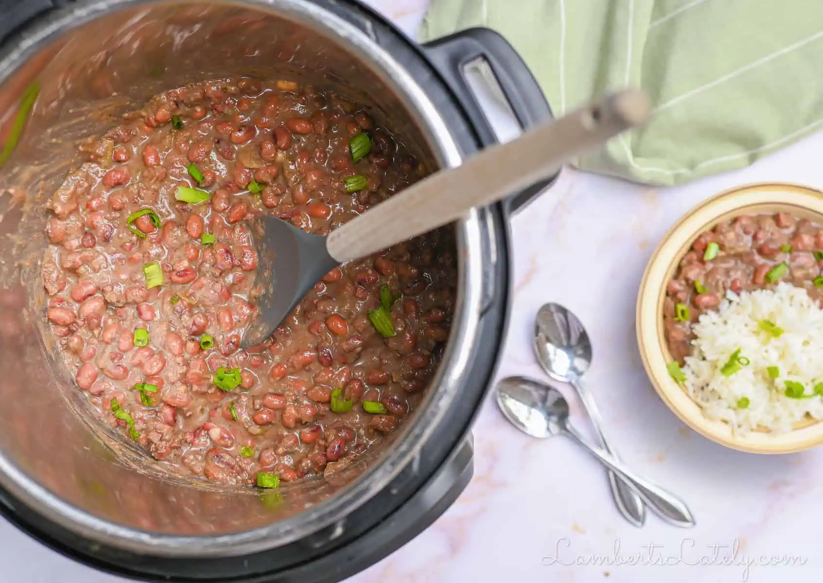 red beans and rice in an instant pot, with a spoon, next to a serving in a bowl.