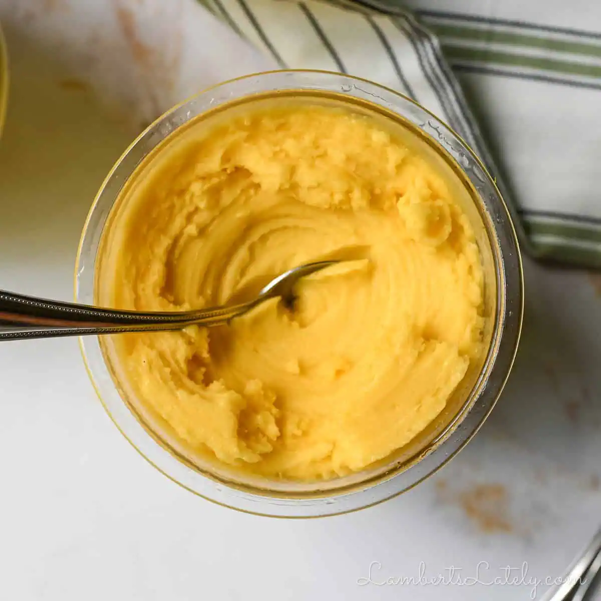 a bowl of mango sorbet with a spoon in it.