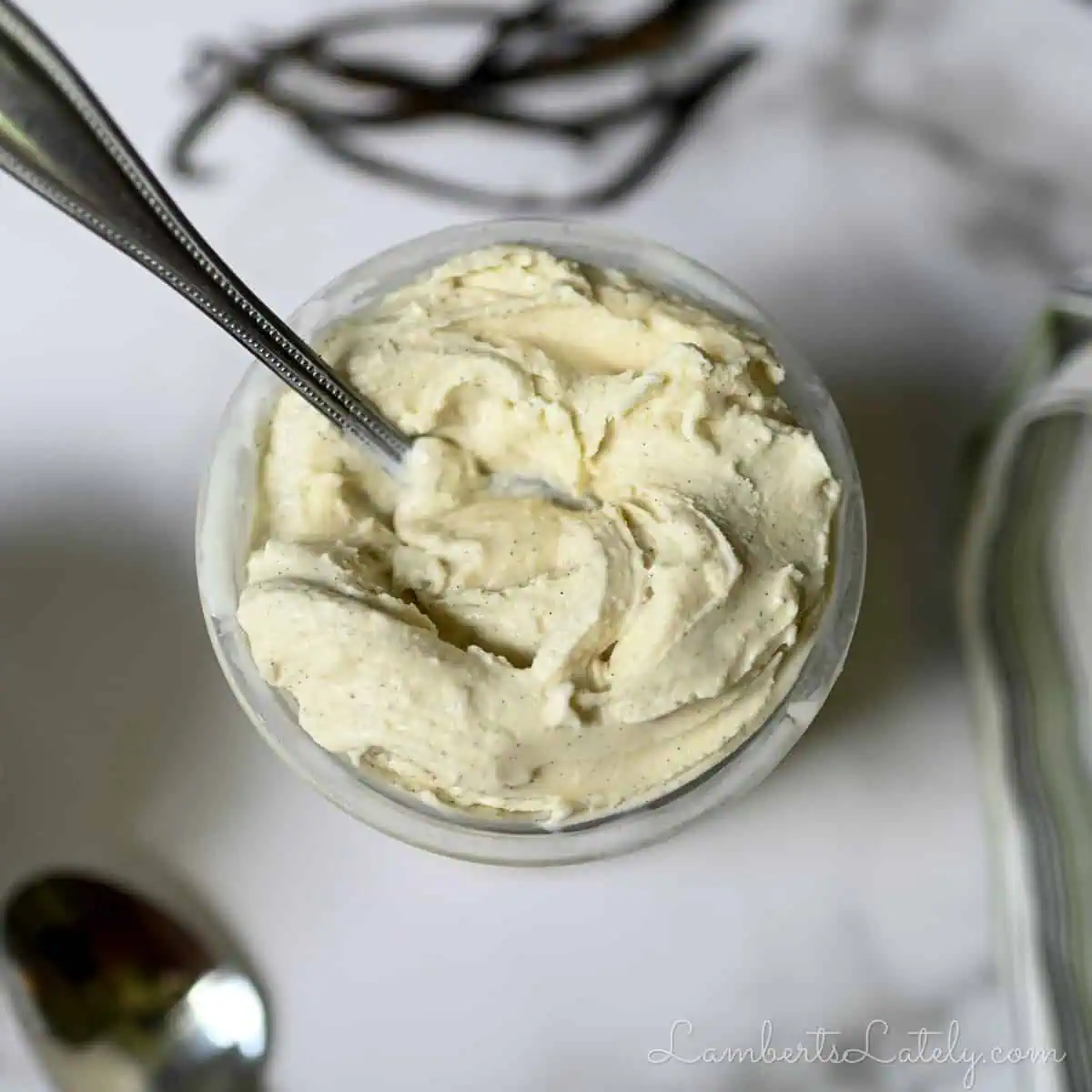 vanilla ice cream in a ninja creami pint container, with a spoon.