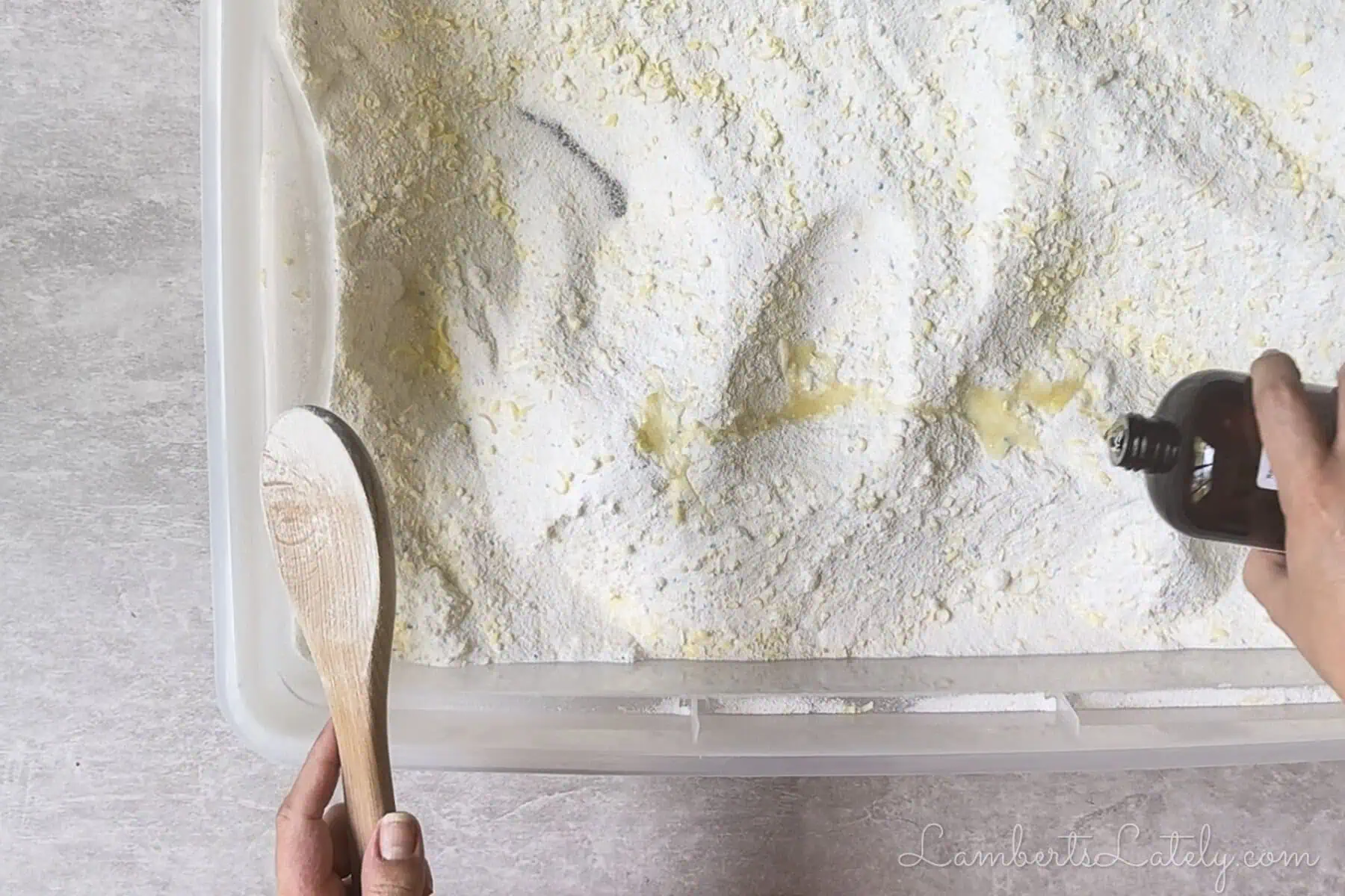 pouring fragrance oil into laundry powder.