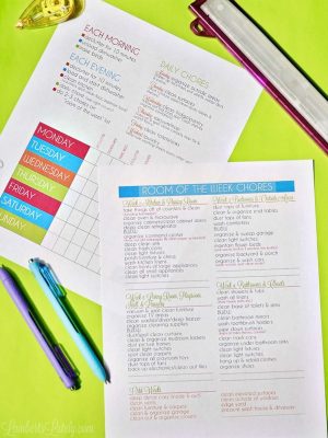 two colorful home cleaning schedules spread around office supplies.
