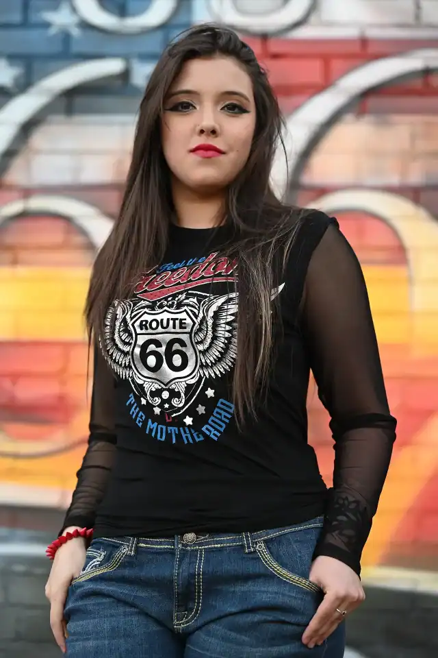 A woman wearing a black Liberty Wear shirt with a design on it