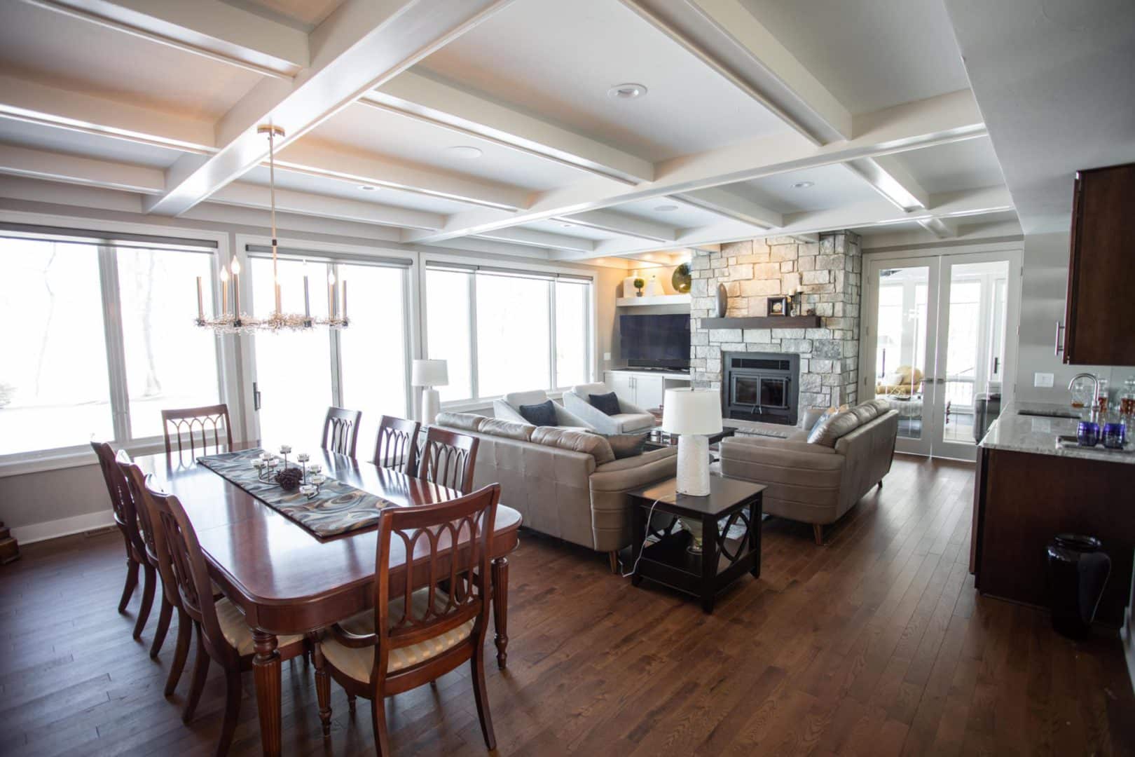 Spacious living room with modern design, large windows, and cozy seating area by the fireplace.