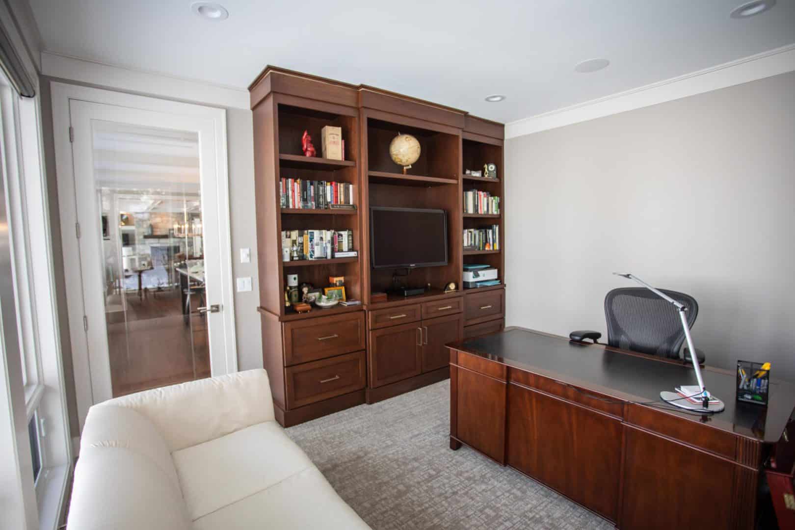 Office space with built-in wooden shelves and a desk setup.