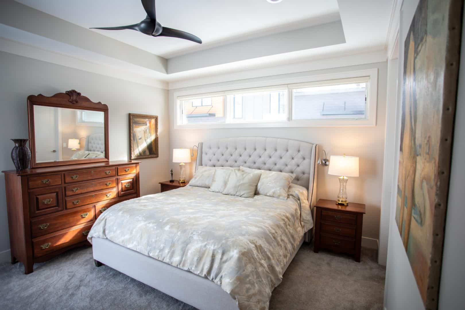 Modern bedroom featuring a large window, tufted headboard, and stylish furniture for a comfortable l.