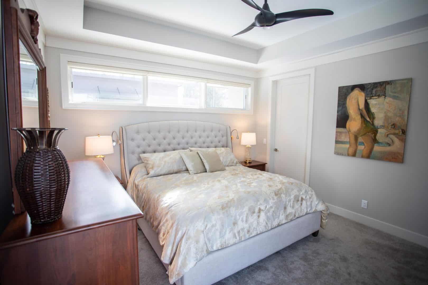 Elegant bedroom with large window, stylish furniture, and contemporary design.