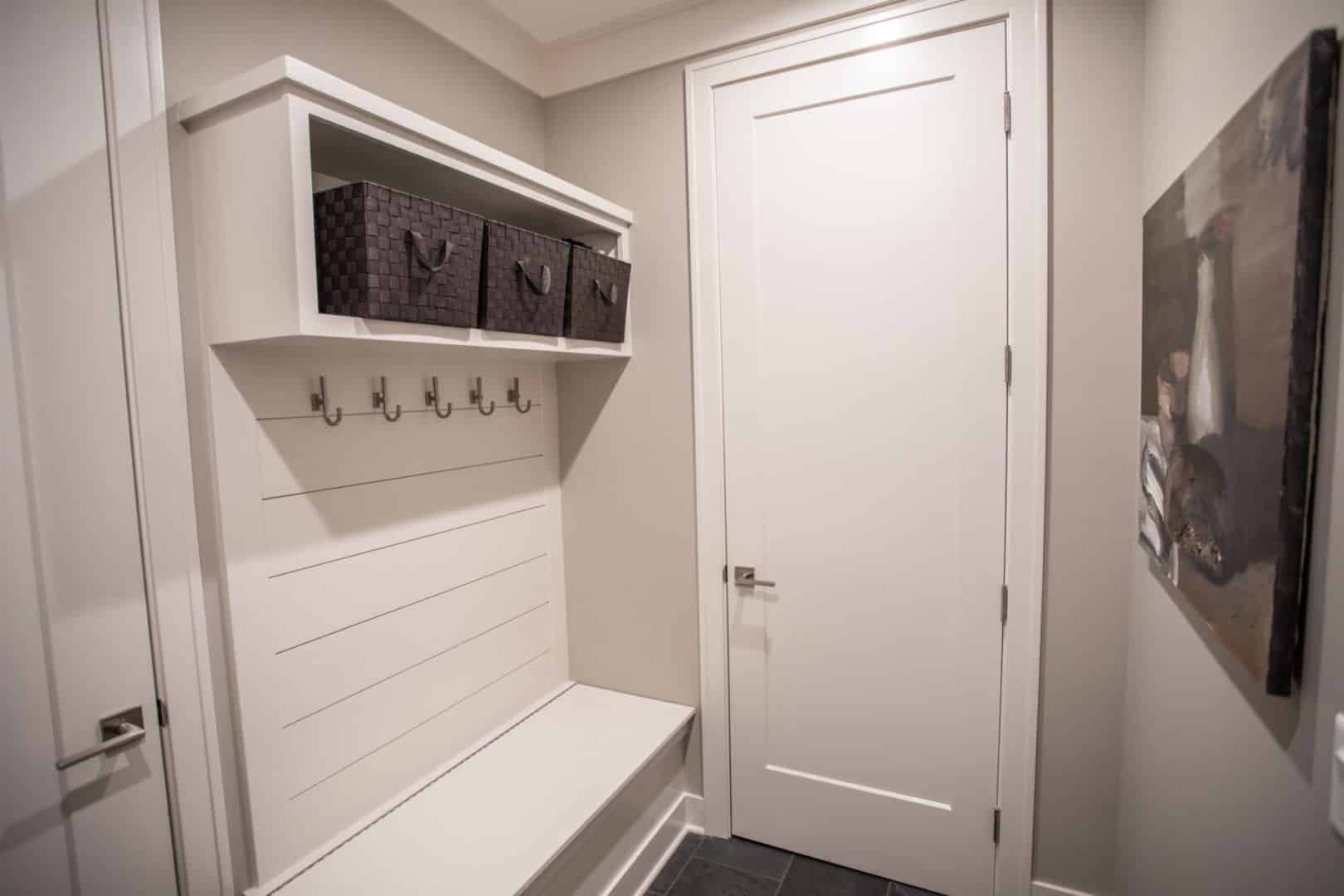 Modern mudroom with storage bench and hooks in Livingston Homes.