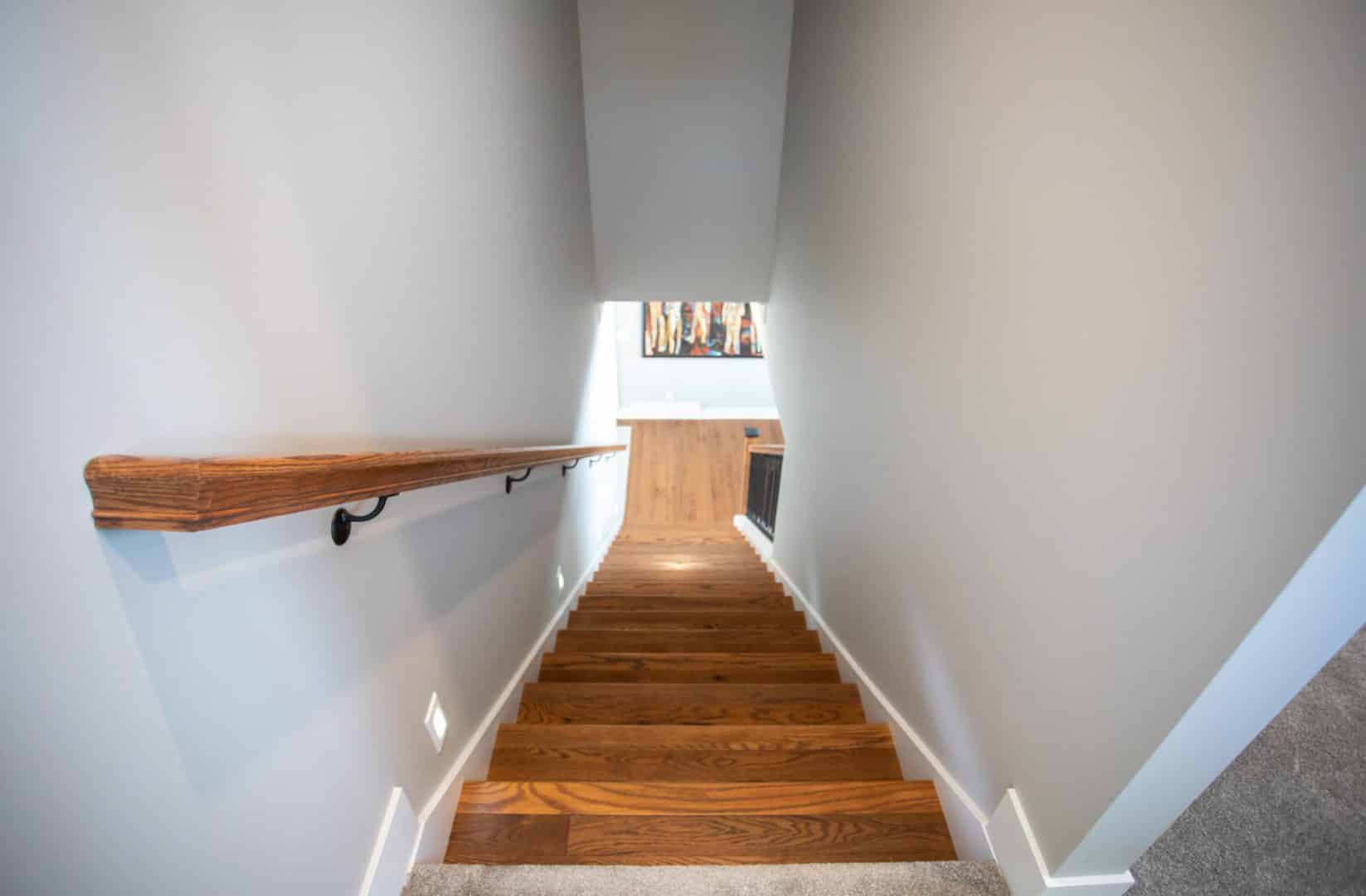 Interior staircase with wooden steps and handrail at Livingston Homes.
