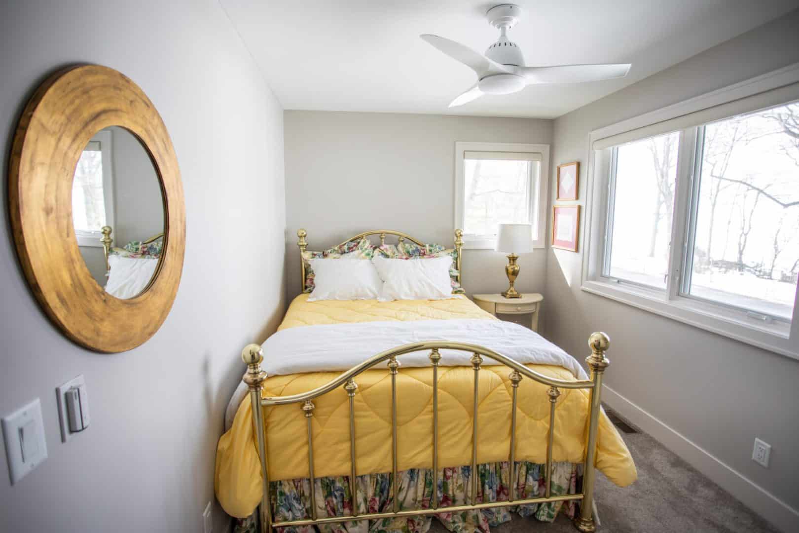 Bright bedroom with gold bed frame and large windows, modern living space.
