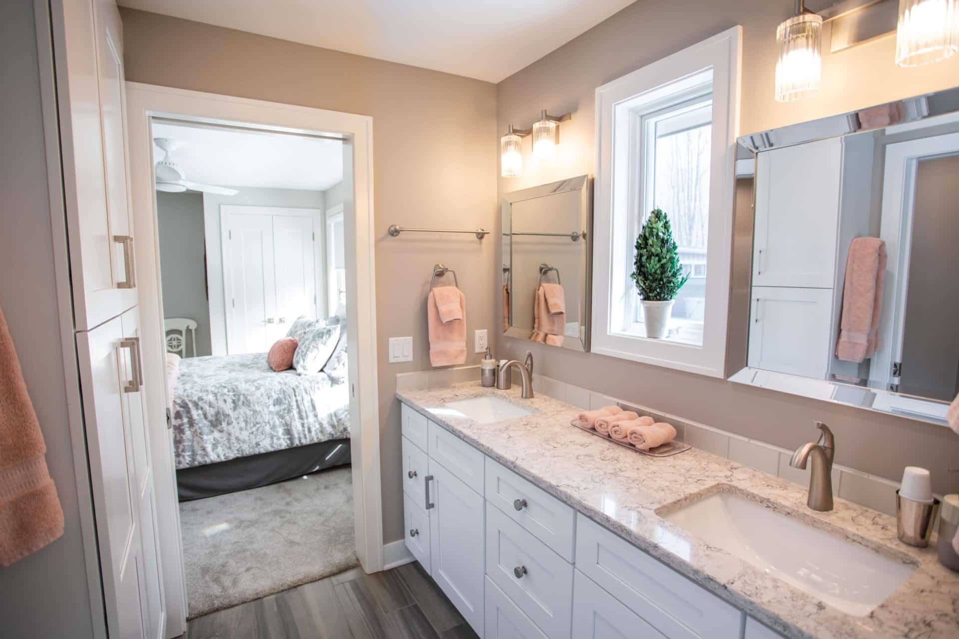Bathroom with double vanity, granite countertops, and large windows providing natural light.
