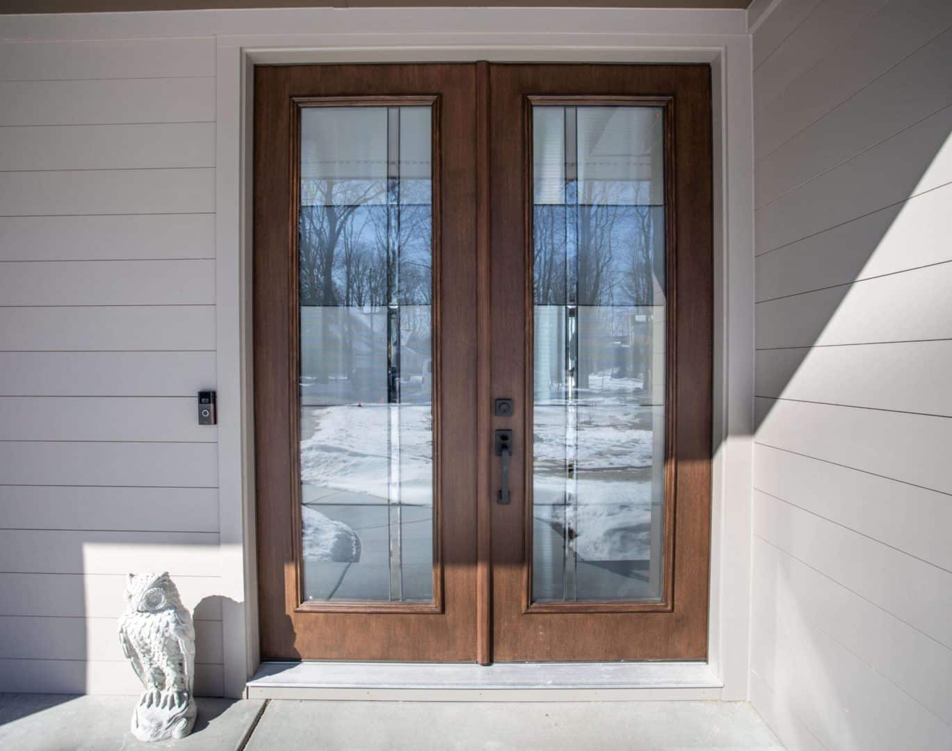 Front door with glass panels and wooden frame.