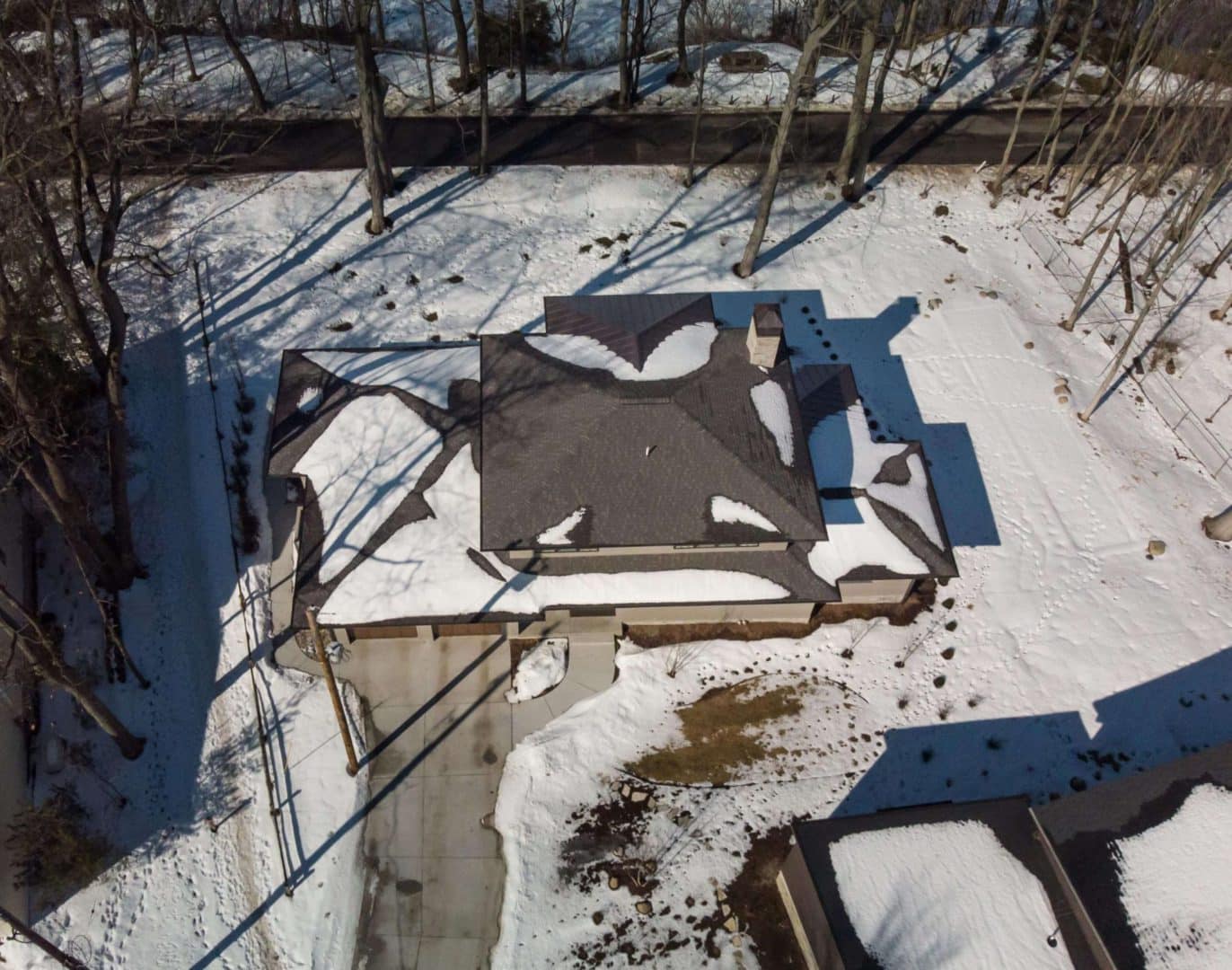 Aerial view of a Livingston Homes house with snow-covered roof in winter.