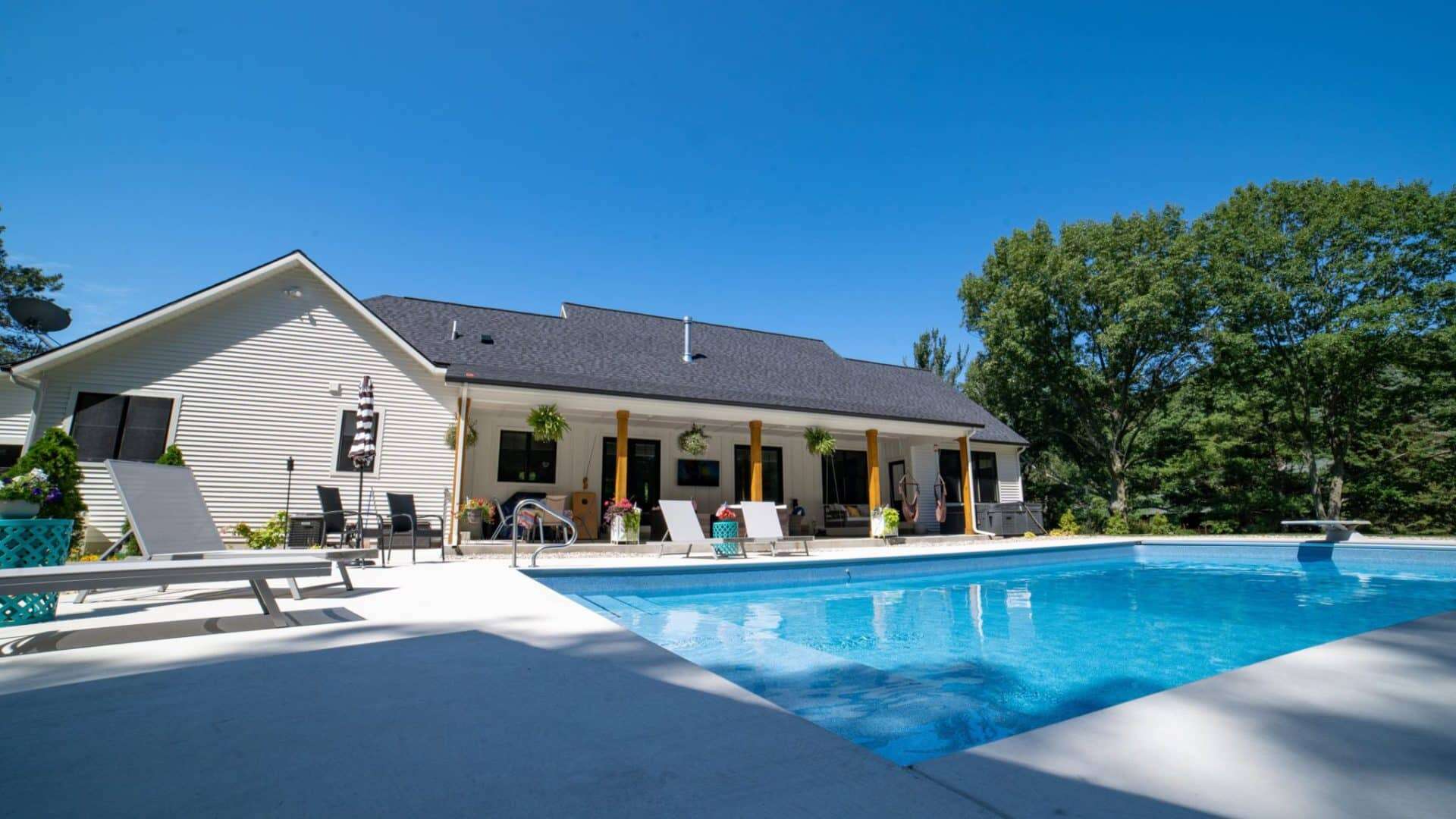 Beautiful Livingston Homes property featuring a large outdoor pool and lounge area under a clear blu.