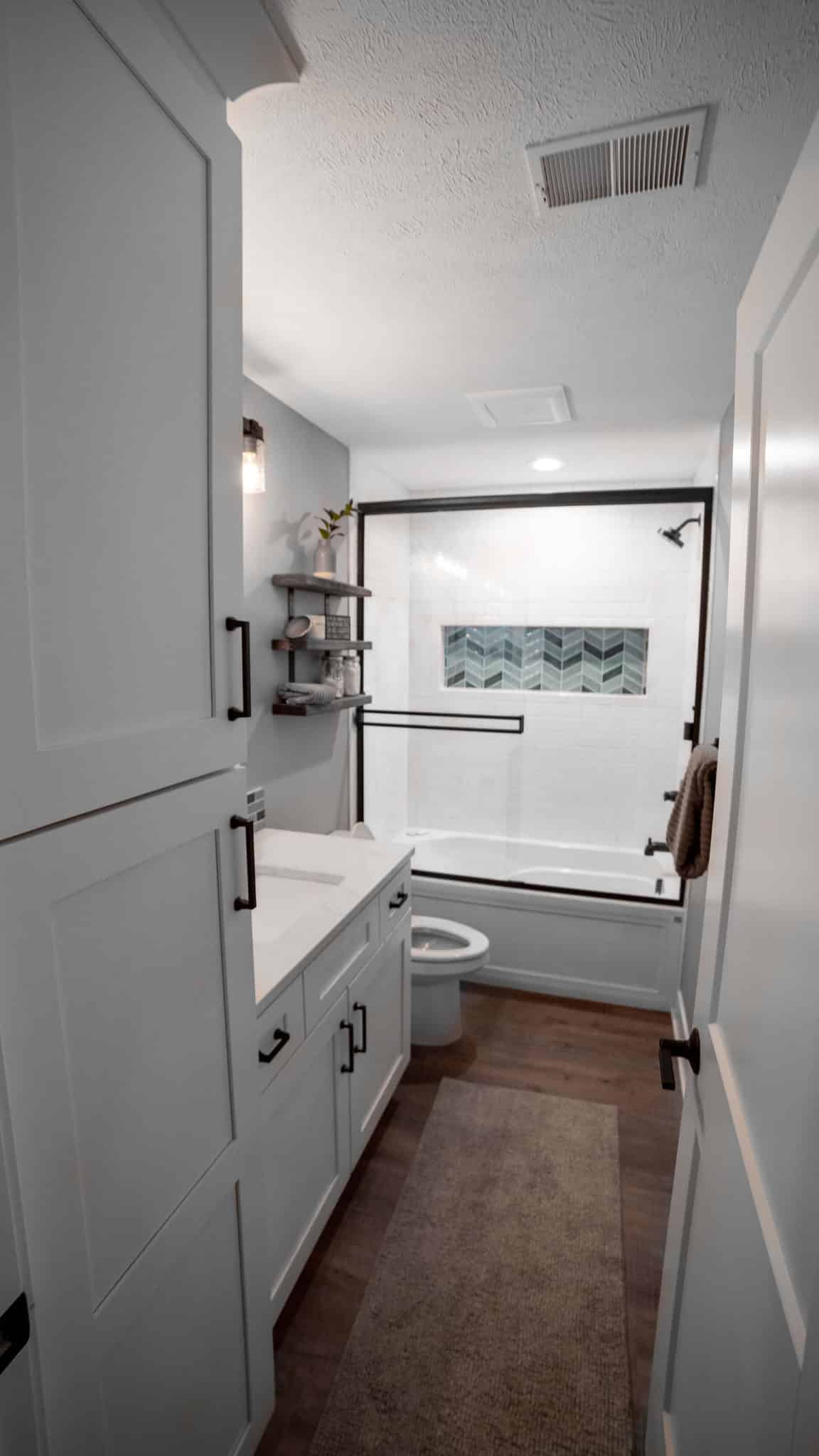 Bathroom with shower, vanity, and storage in a contemporary home.
