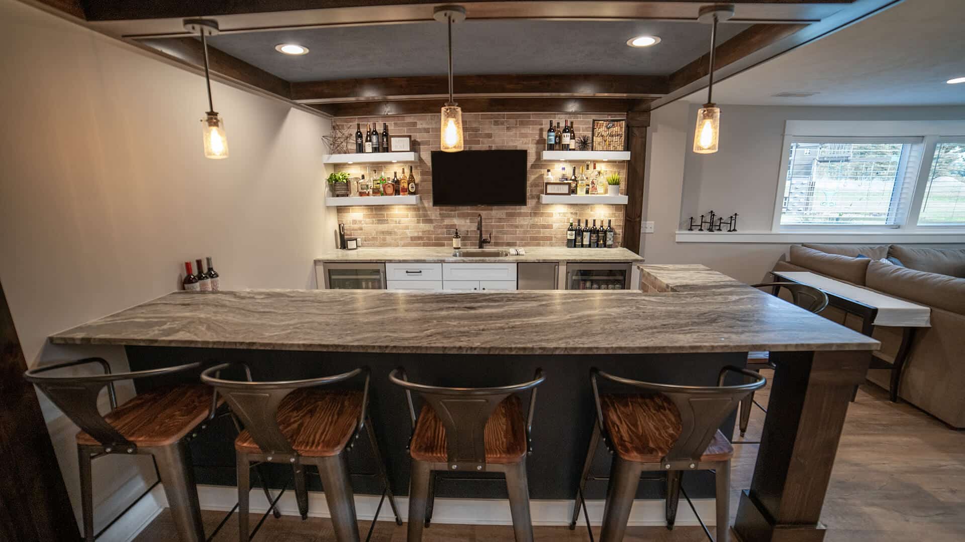 Home bar with contemporary design, pendant lighting, and a cozy seating area in a living space.