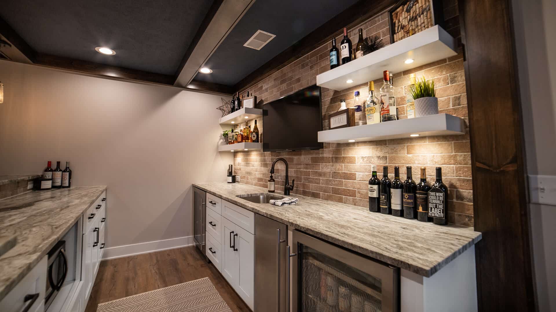 Modern kitchen with brick accent wall, open shelves, and granite countertops in Livingston Homes.