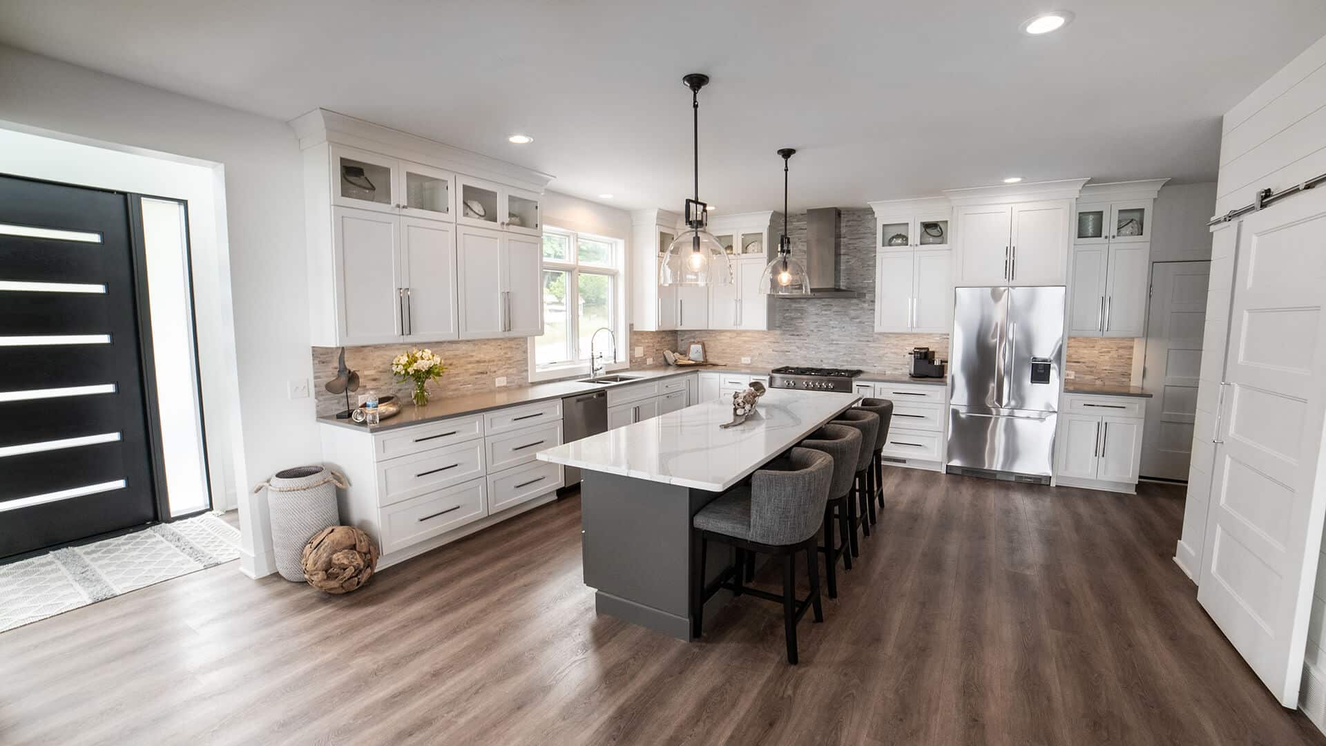 Bright, spacious kitchen featuring white cabinets, a large island, and stainless steel appliances fo.