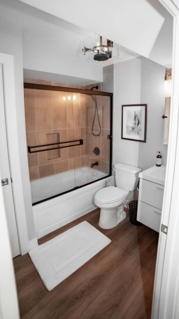 Modern bathroom featuring a glass shower, toilet, and minimalist decor.