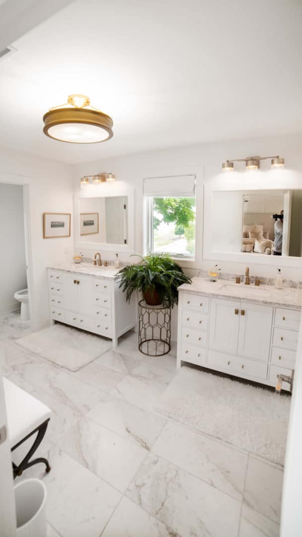 Bright modern bathroom with double vanities, large mirrors, and natural light.