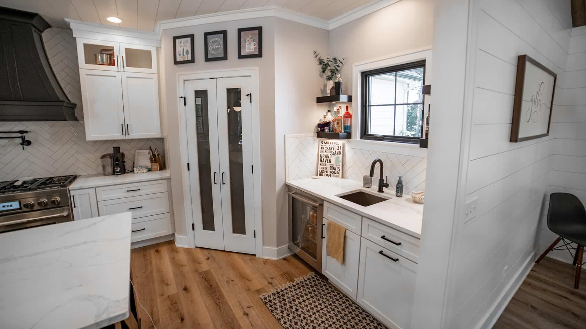 Bright kitchen featuring white cabinetry, black hardware, and a farmhouse sink with natural light.
