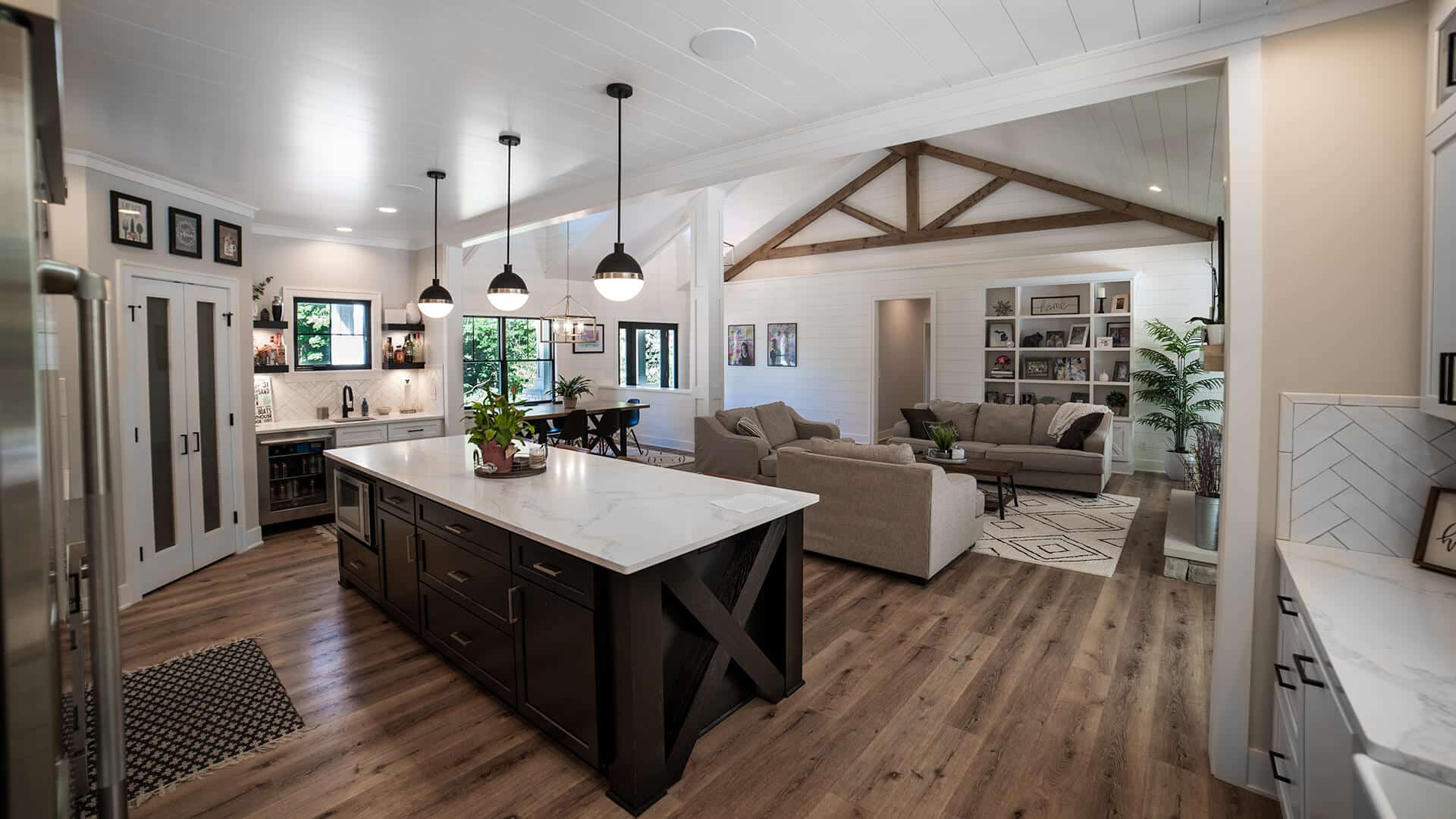 Spacious living room featuring an open-concept kitchen, vaulted ceiling, and contemporary decor in L.