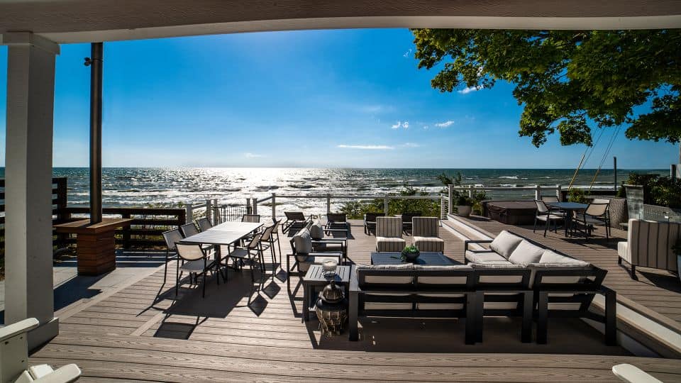 Waterfront deck with outdoor seating and ocean view at Livingston Homes. Perfect for relaxing and en.