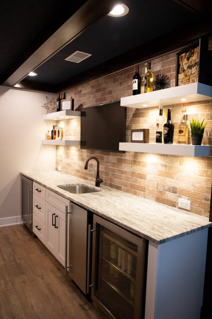 Modern kitchen with brick backsplash, open shelves, and mini fridge for stylish living spaces.