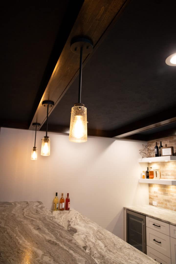 Pendant lighting over marble kitchen island in a modern Livingston Homes kitchen.