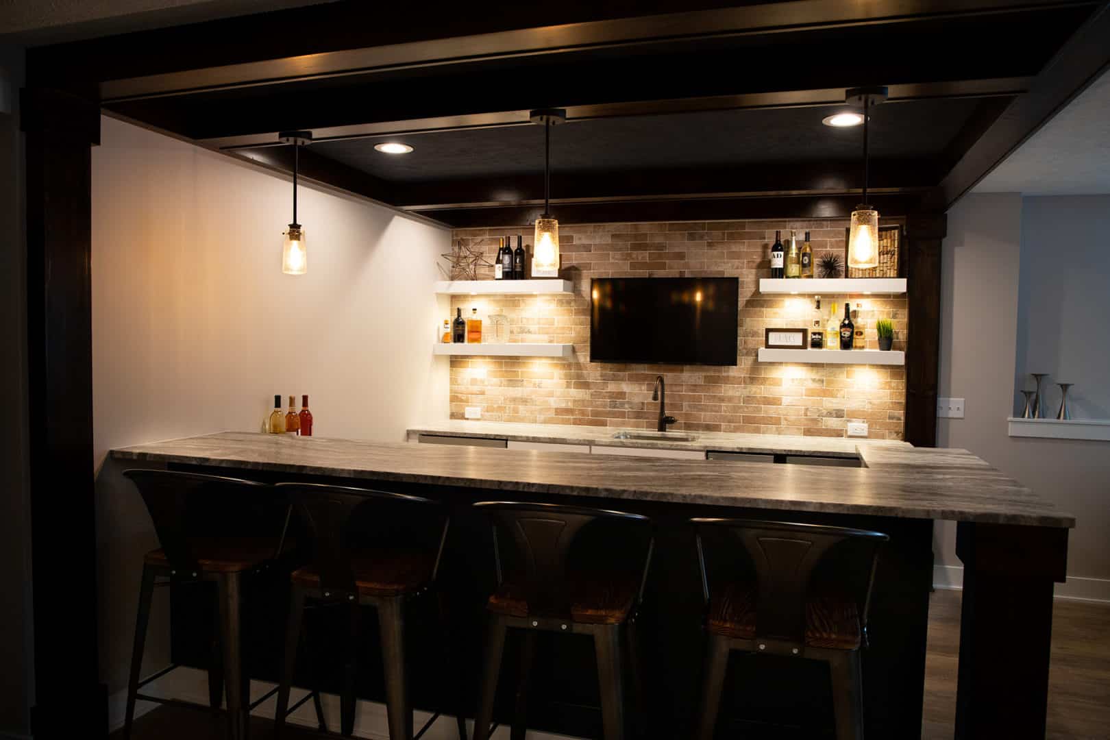 Modern bar area with brick backsplash and pendant lighting.