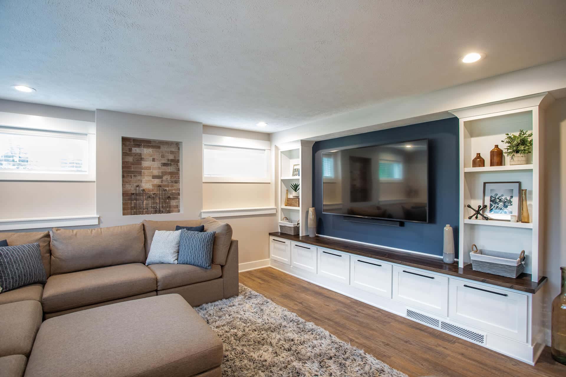 Modern living room with built-in entertainment center and cozy seating.