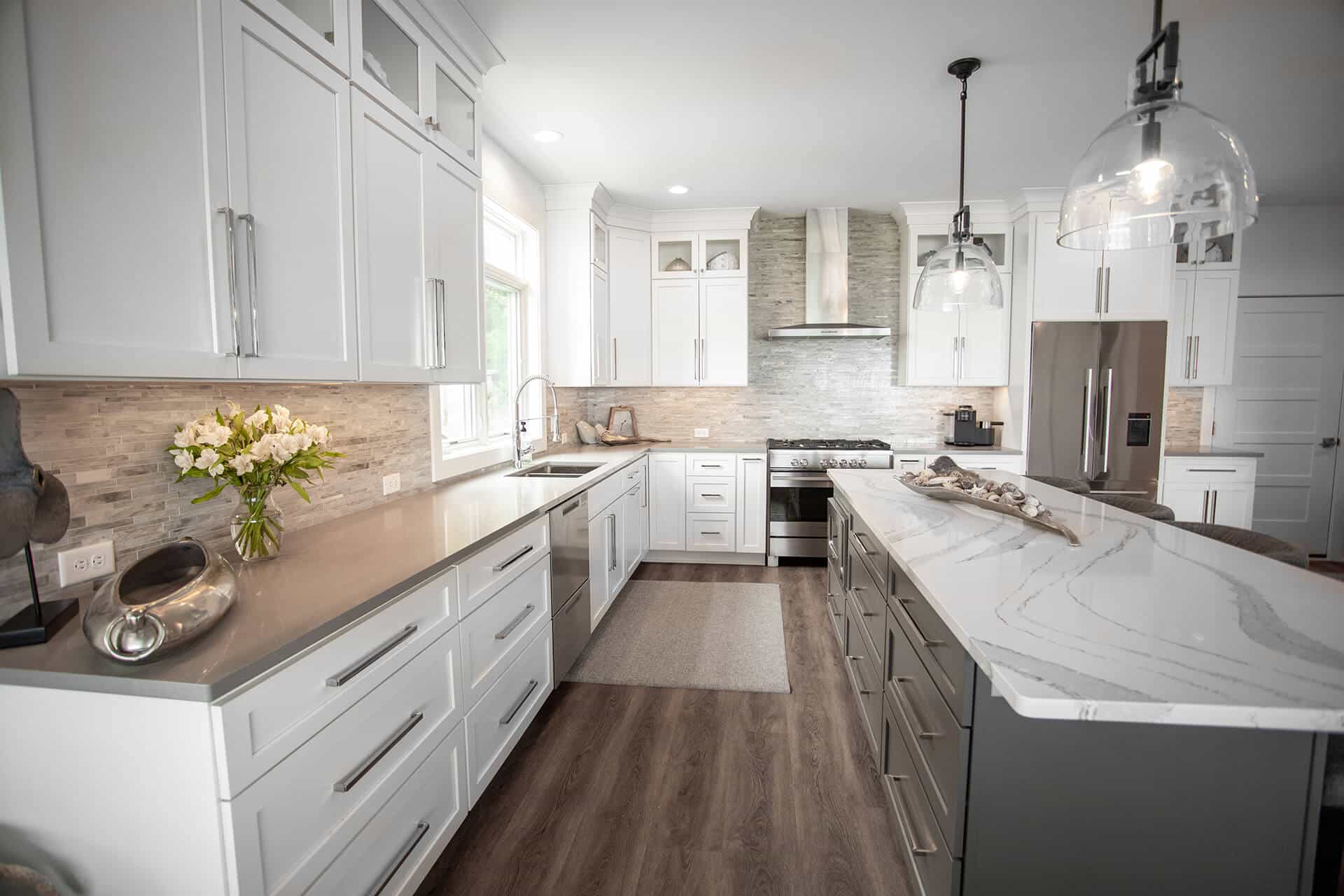Bright, spacious kitchen featuring white cabinetry and marble countertops for a sleek, contemporary.