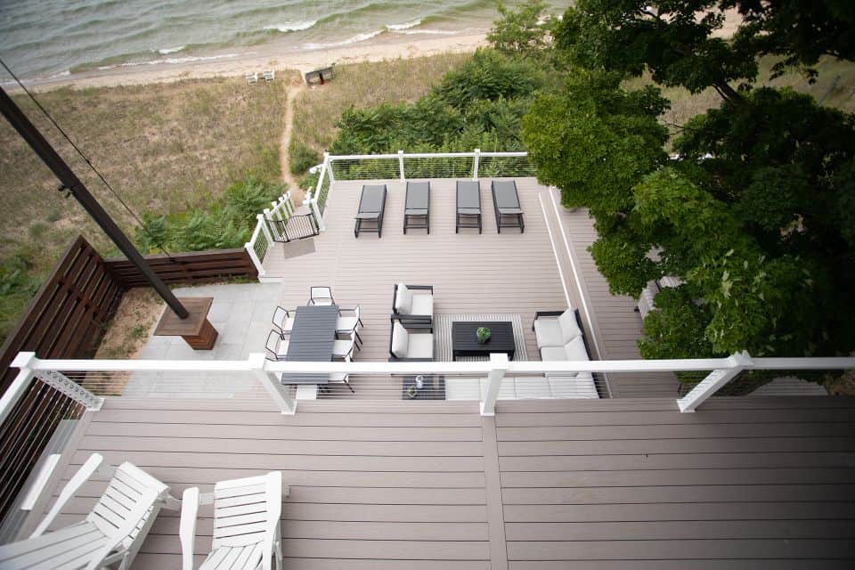 Beachfront deck with outdoor seating and sun loungers.