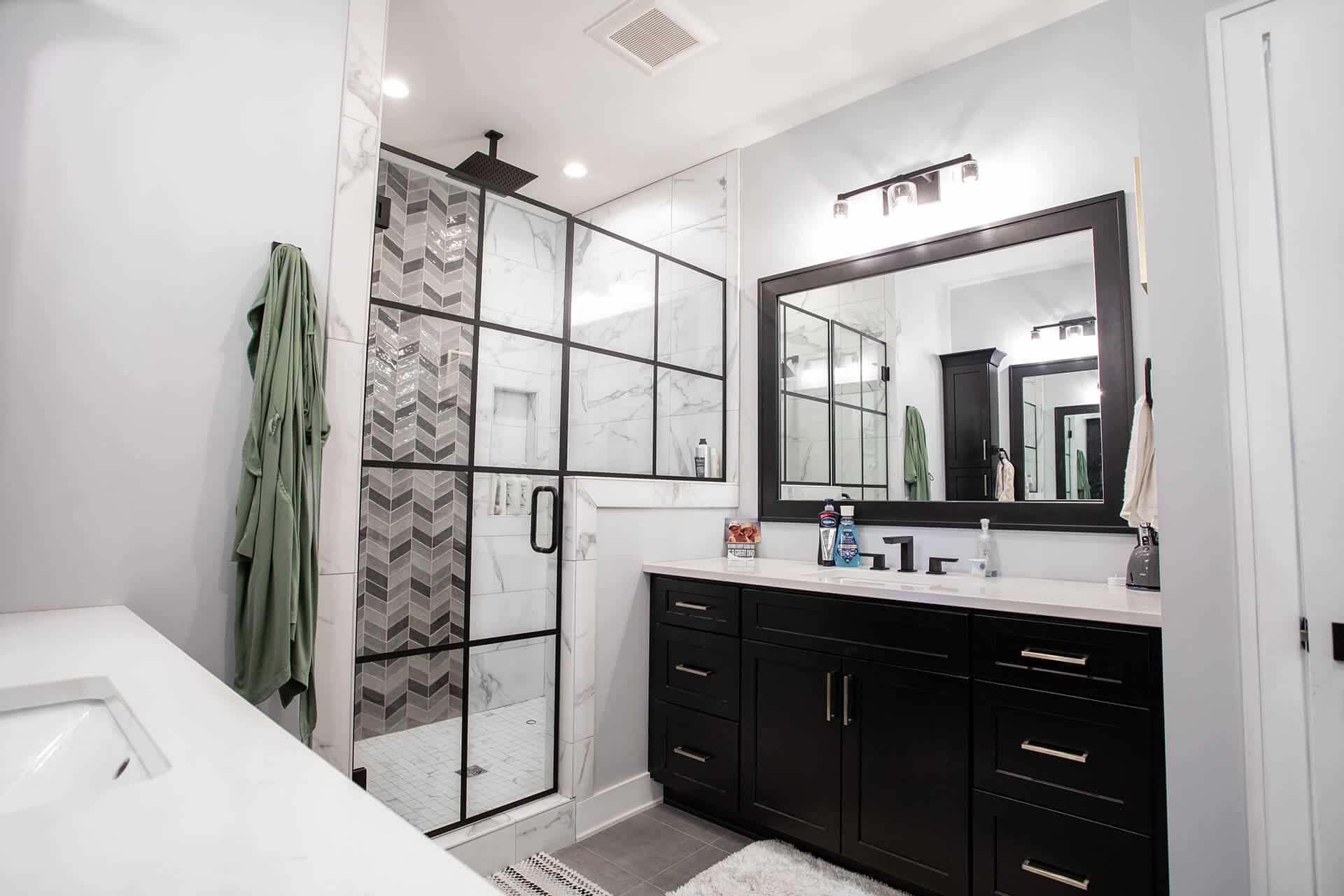 Modern bathroom with glass shower and sleek black vanity.