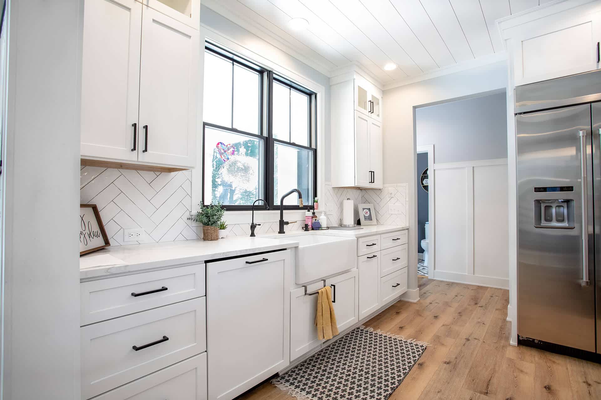 Bright modern kitchen with white cabinets and stainless steel appliances.