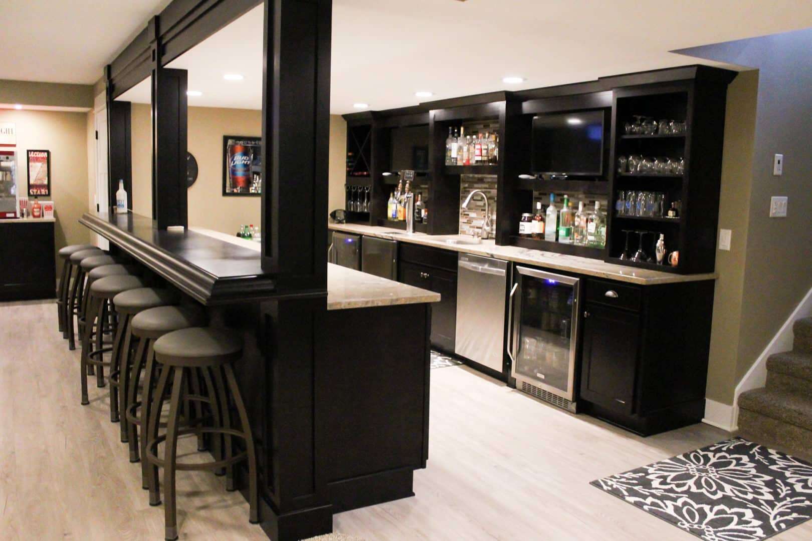 Bar area with black cabinetry and a variety of beverages at Livingston Homes.