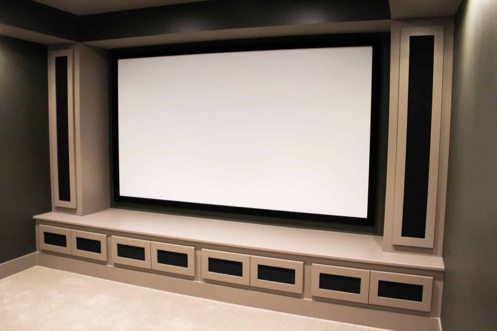 Home theater room with custom built-in cabinetry and large projection screen.