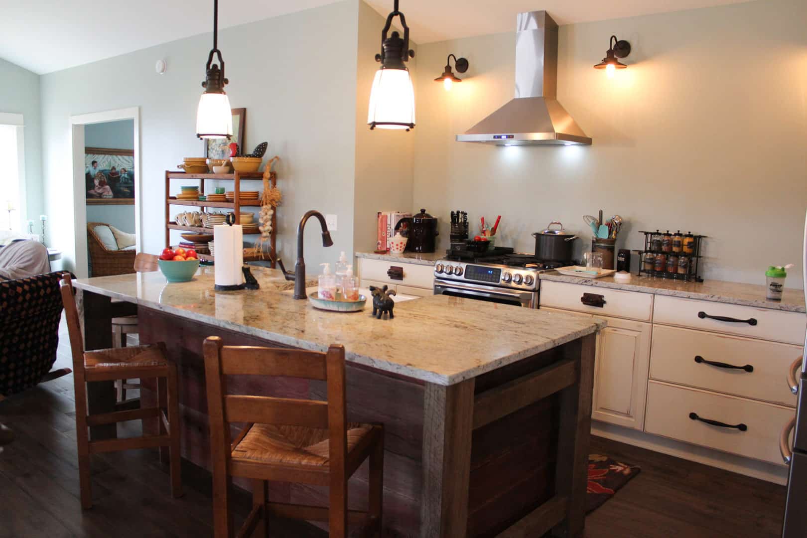 Bright modern kitchen with island, pendant lights, and stainless steel appliances.