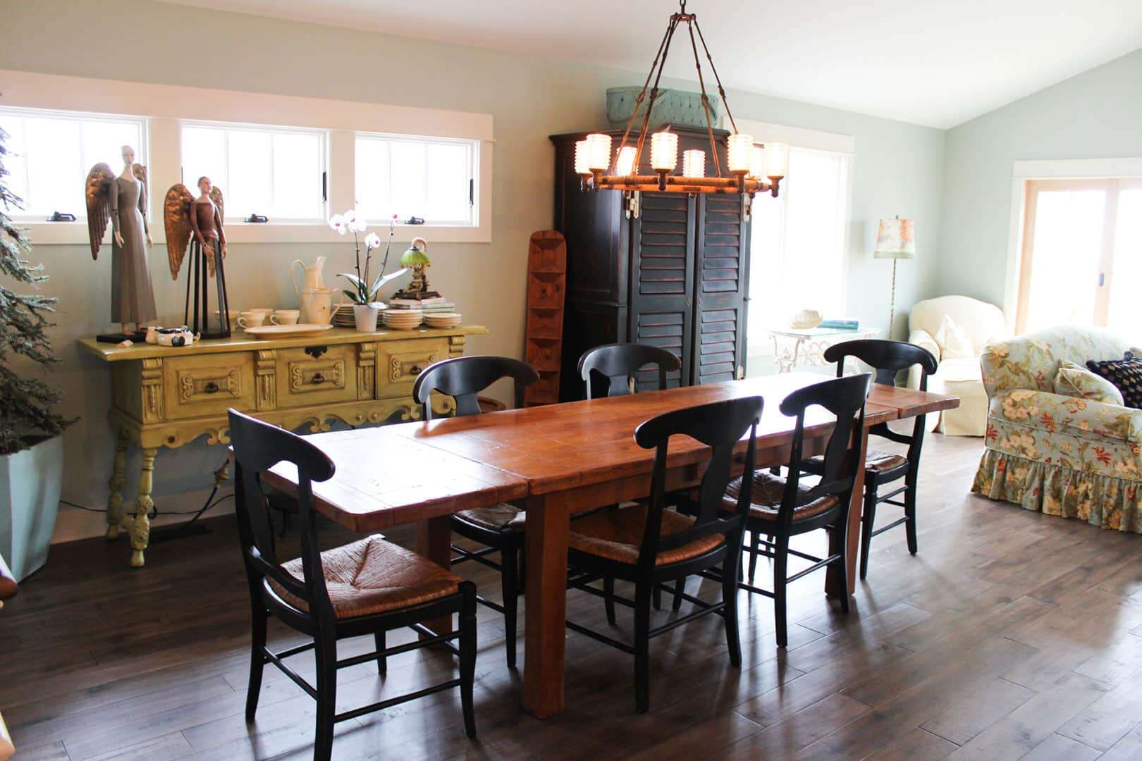 Livingston Homes dining room with a wooden table and black chairs, bright natural light, and cozy de.