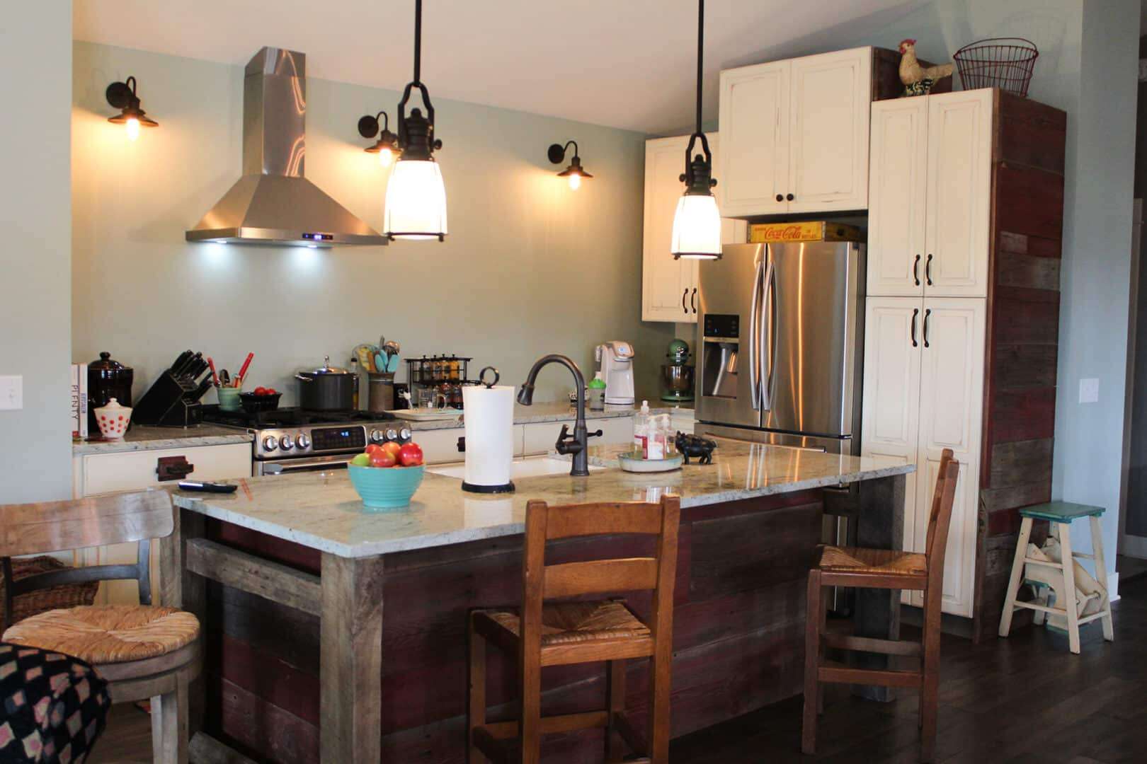 Contemporary kitchen featuring stainless steel appliances, pendant lighting, and a rustic island for.