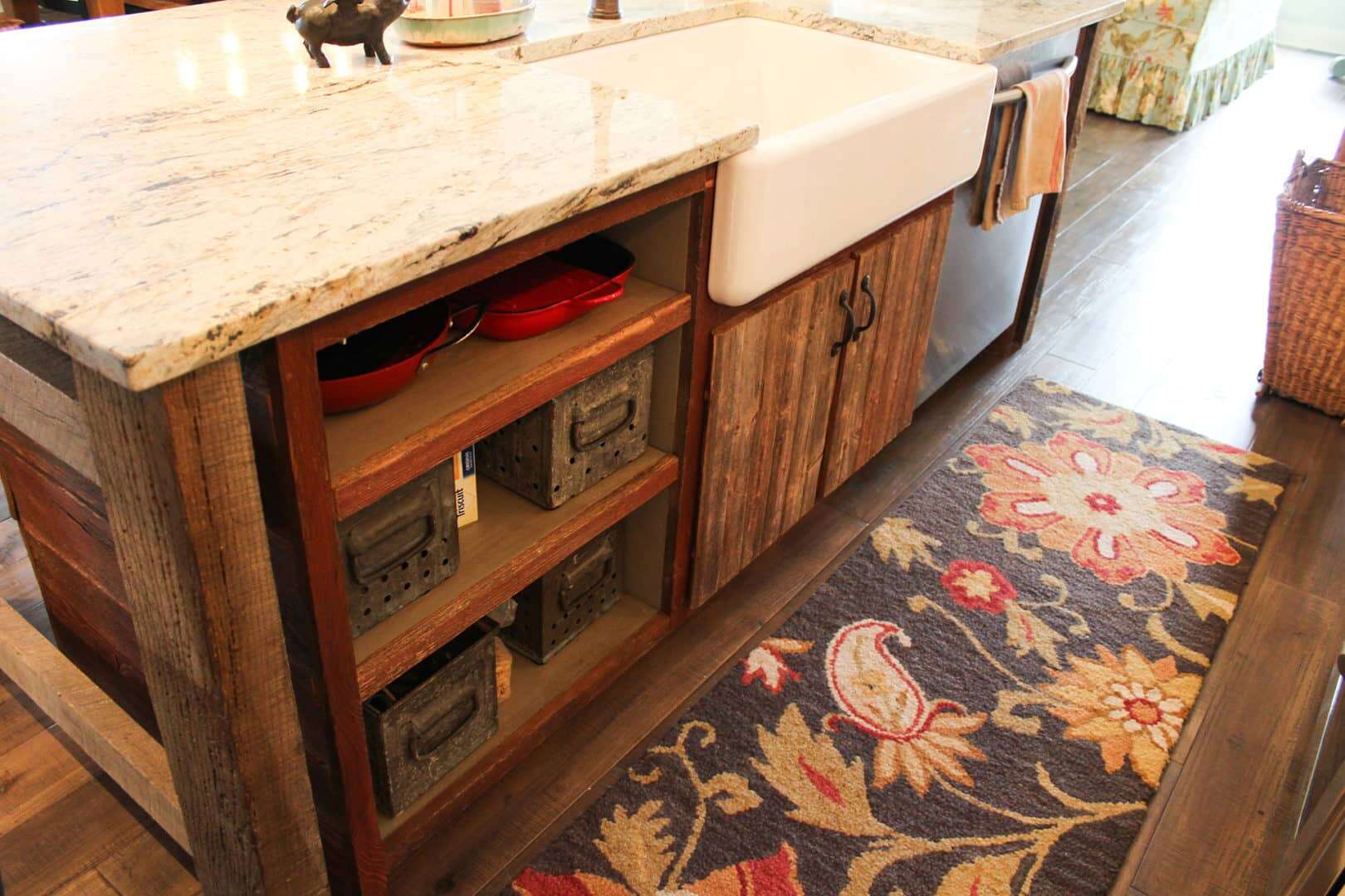 Rustic kitchen cabinet with open shelves and a floral rug.
