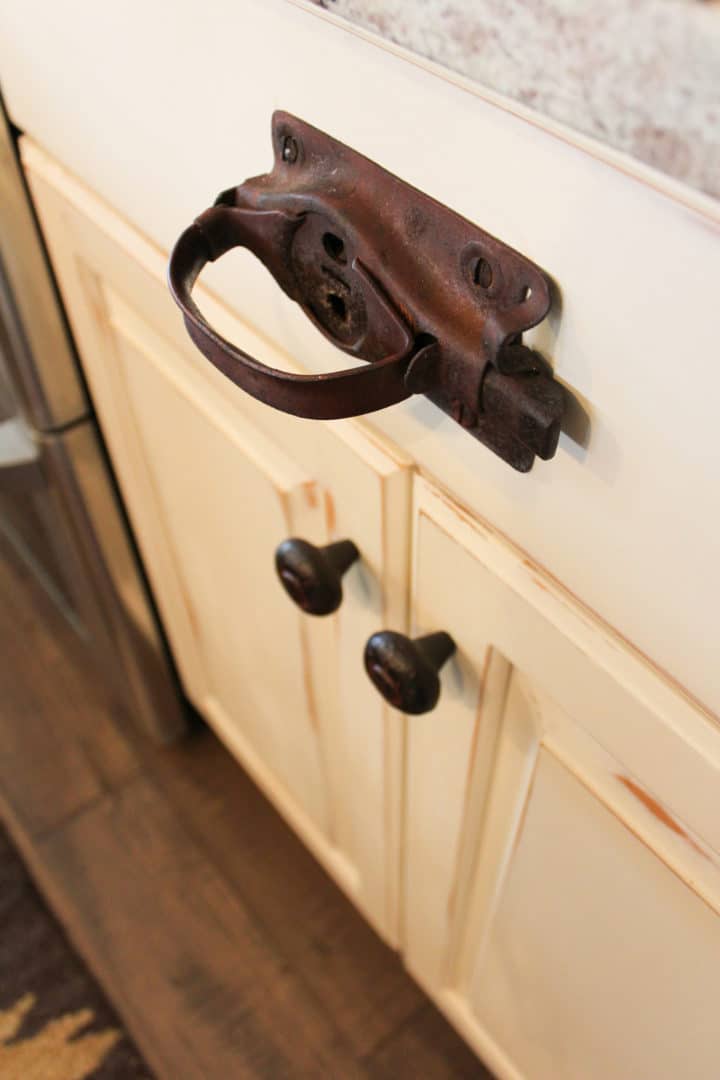 Rustic iron drawer handle on kitchen cabinet.