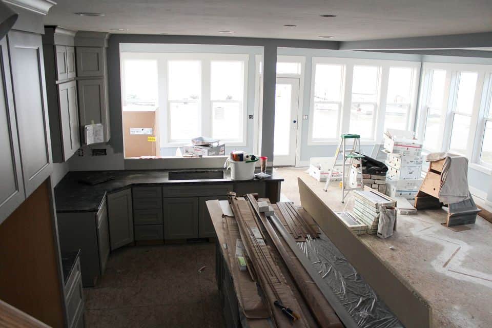 Bright kitchen with large windows and ongoing renovation work.