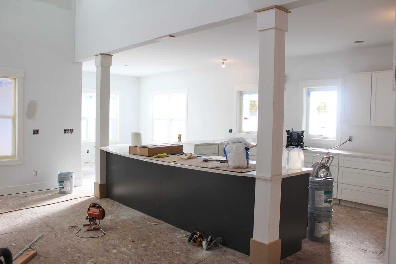 Bright, open-concept kitchen featuring a central island and large windows for ample sunlight.