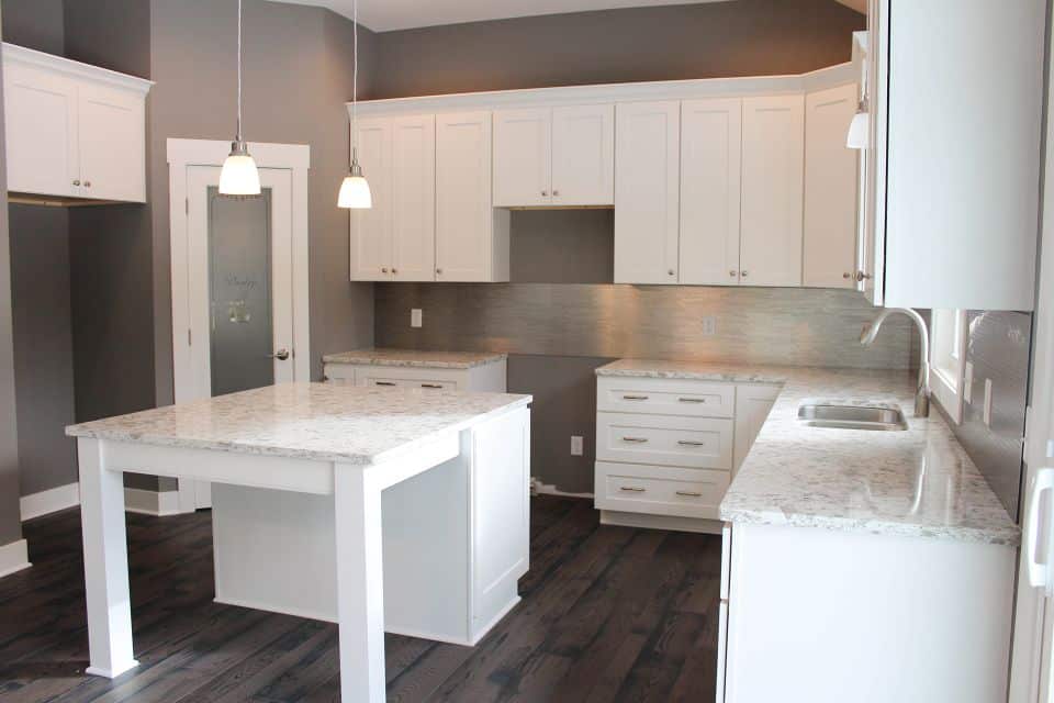 Modern kitchen with white cabinets and granite countertops.
