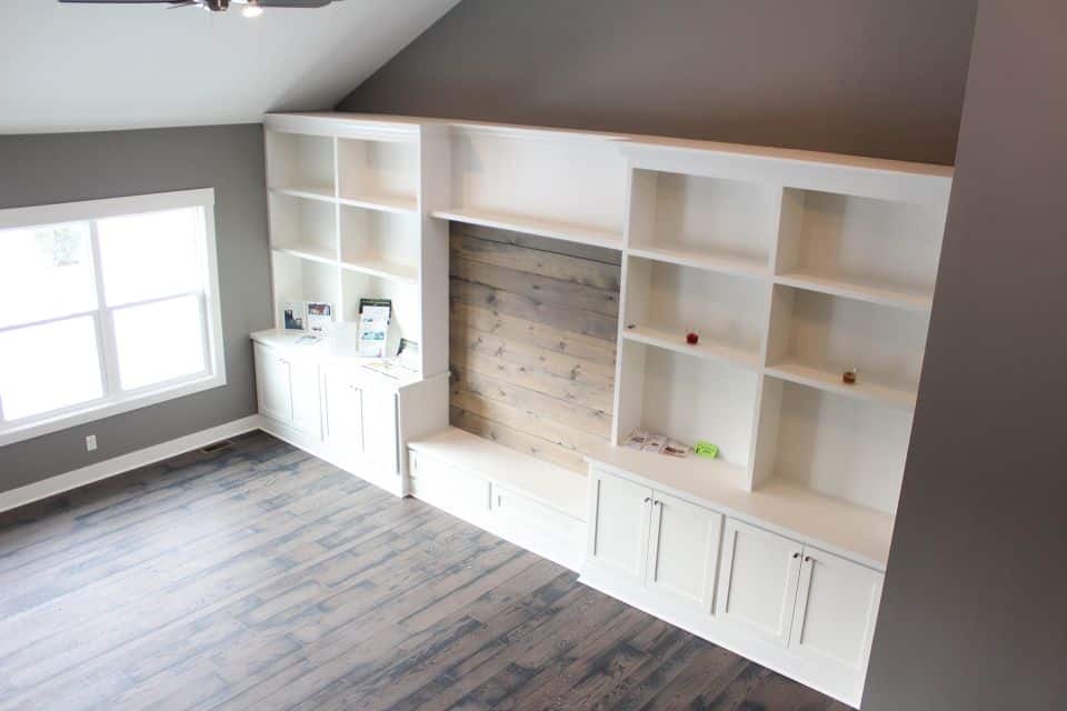 Built-in white shelves and fireplace in a contemporary living room setting.