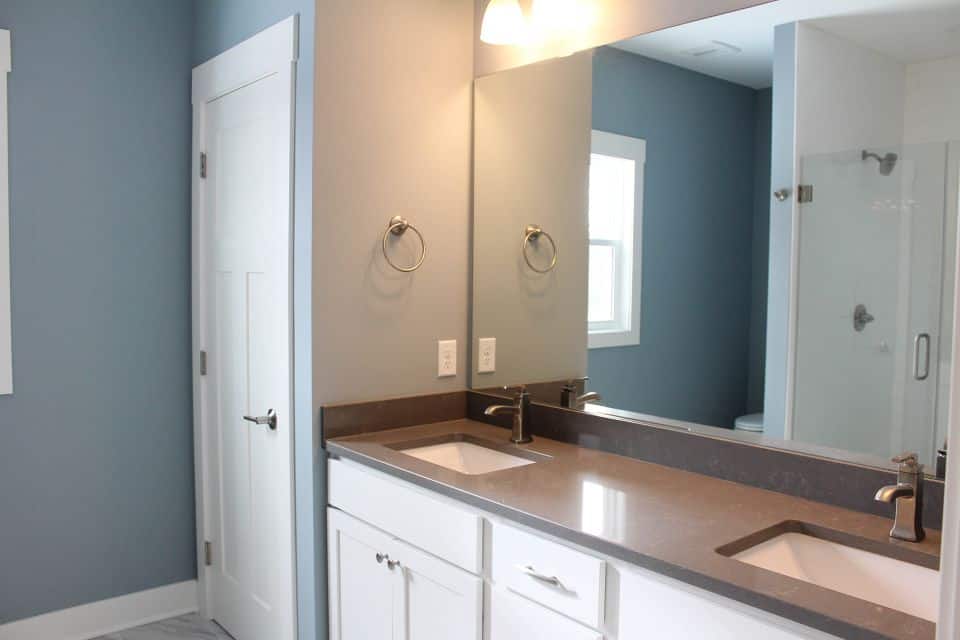 Modern bathroom vanity with dual sinks and large mirror for contemporary living.