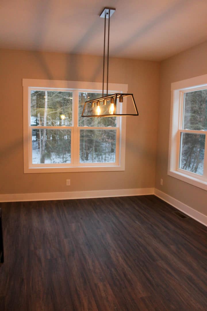 Bright dining area featuring spacious windows and contemporary pendant lighting.