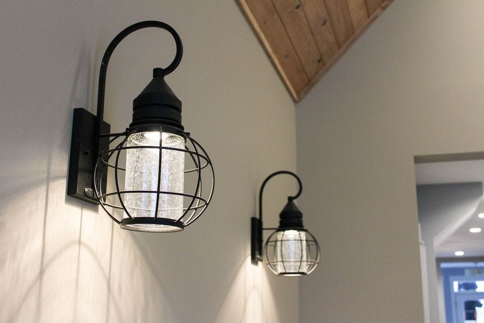 Wall-mounted industrial style sconce with metal cage design.