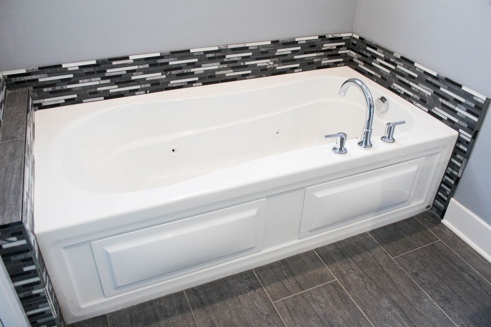 Bathtub with sleek chrome fixtures in a modern bathroom setting.