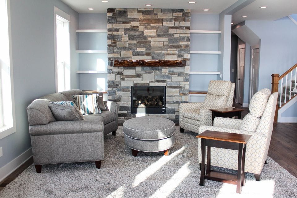 Cozy living room with modern furniture and a stone fireplace at Livingston Homes.